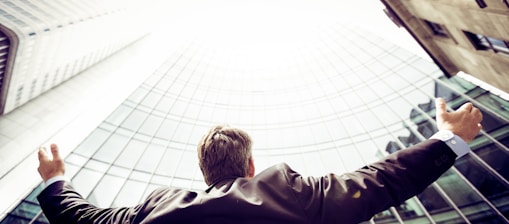 low-angle photography of man in the middle of buidligns