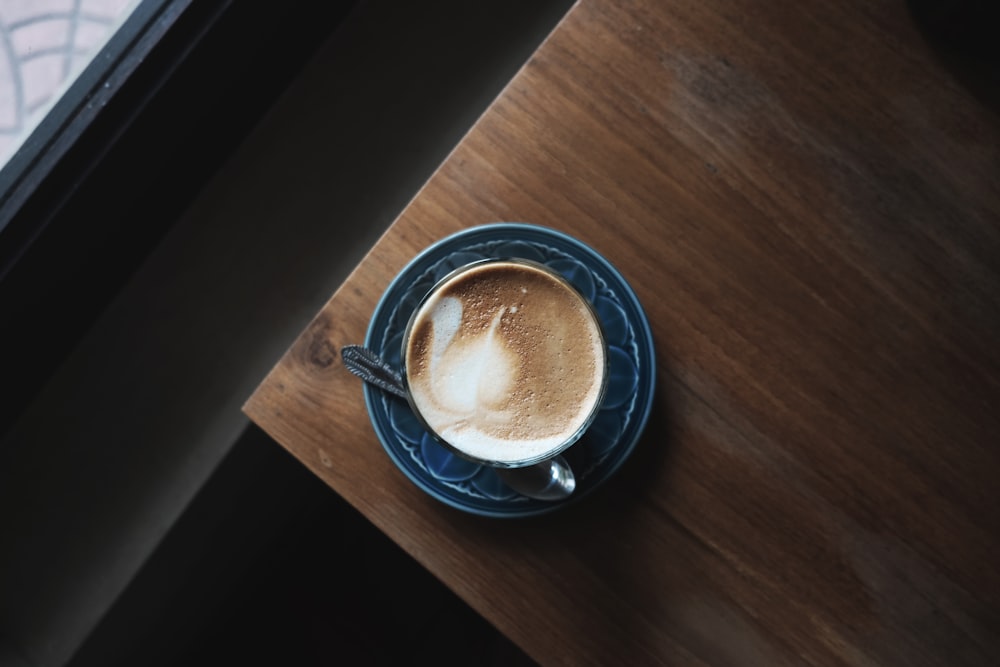 liquide brun sur tasse à thé en céramique bleue