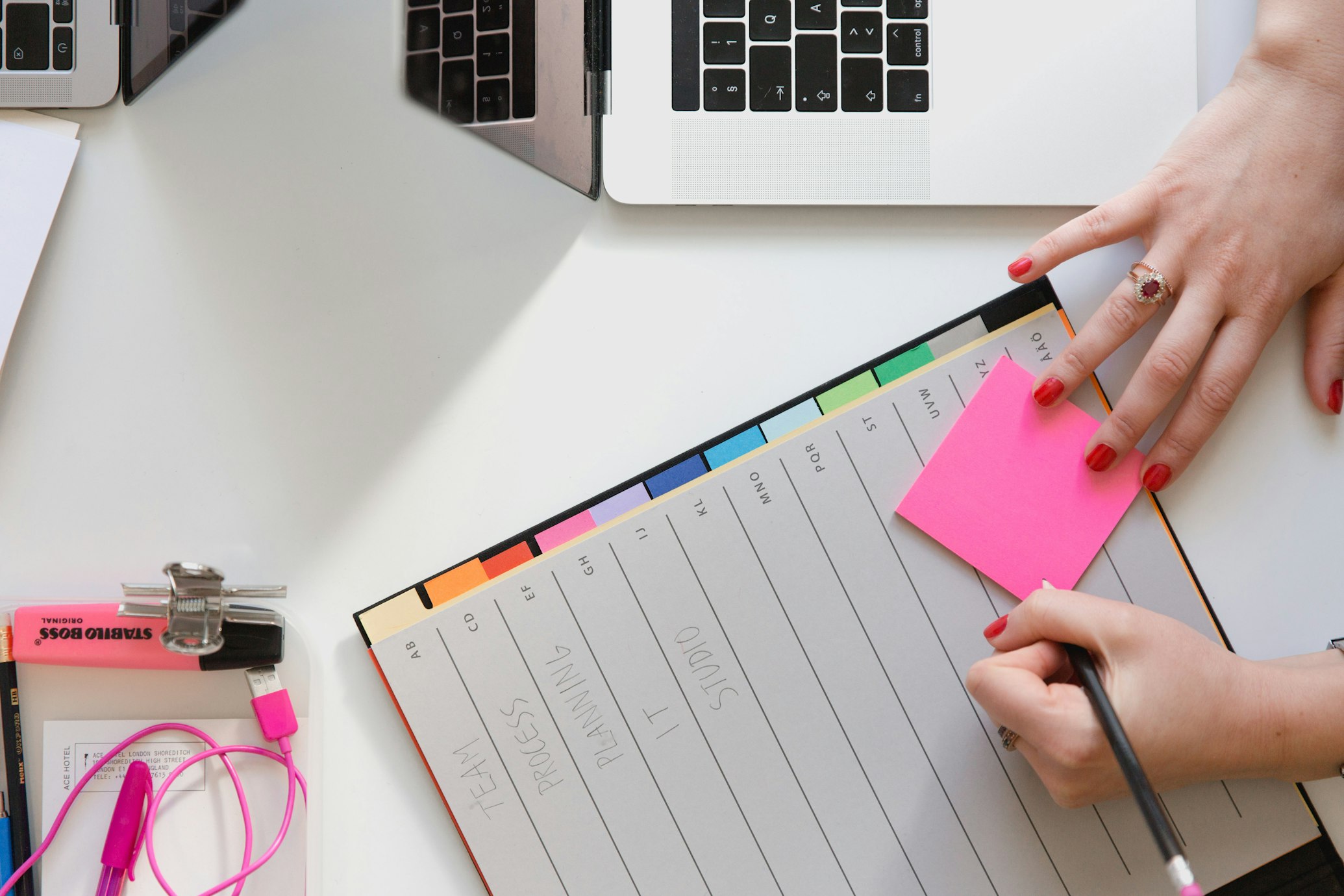 a person writing a sticky note. 