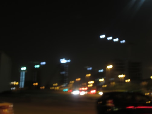 A blurred cityscape at night, suggesting secret meetings nearby.