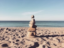 stacked stones on the sea shore during daytime