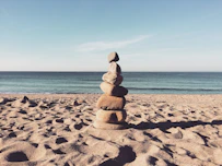stacked stones on the sea shore during daytime