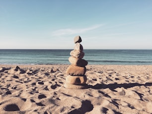 stacked stones on the sea shore during daytime