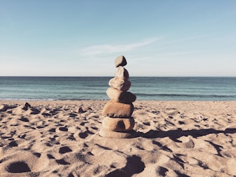 stacked stones on the sea shore during daytime