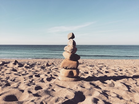 stacked stones on the sea shore during daytime