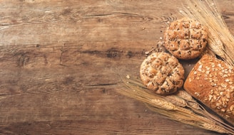 Close-up of wheat grains and fresh fruits on rustic wooden surface