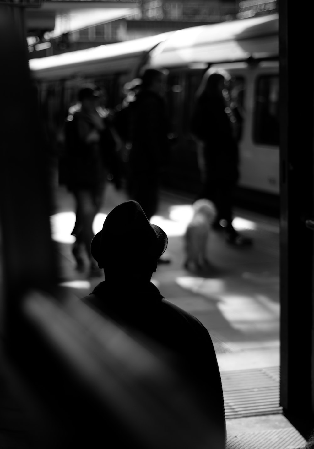 Foto en escala de grises de una persona parada en la estación de tren
