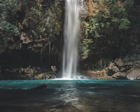 waterfalls between trees at daytime