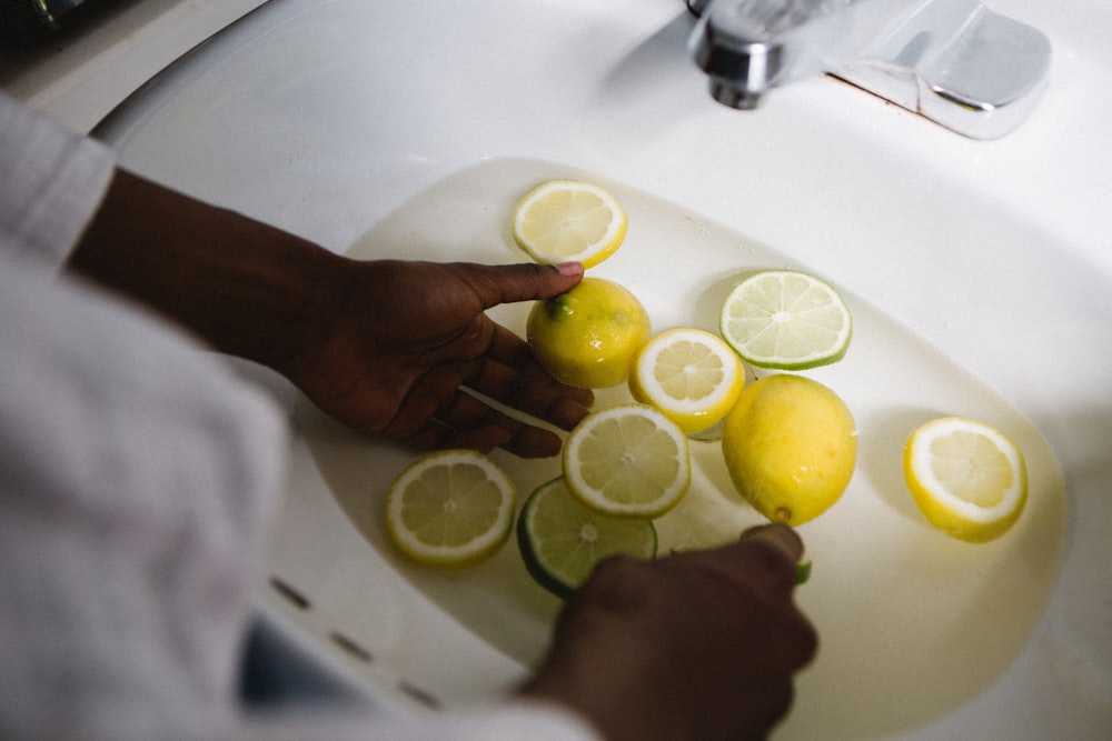 persona cortando limones