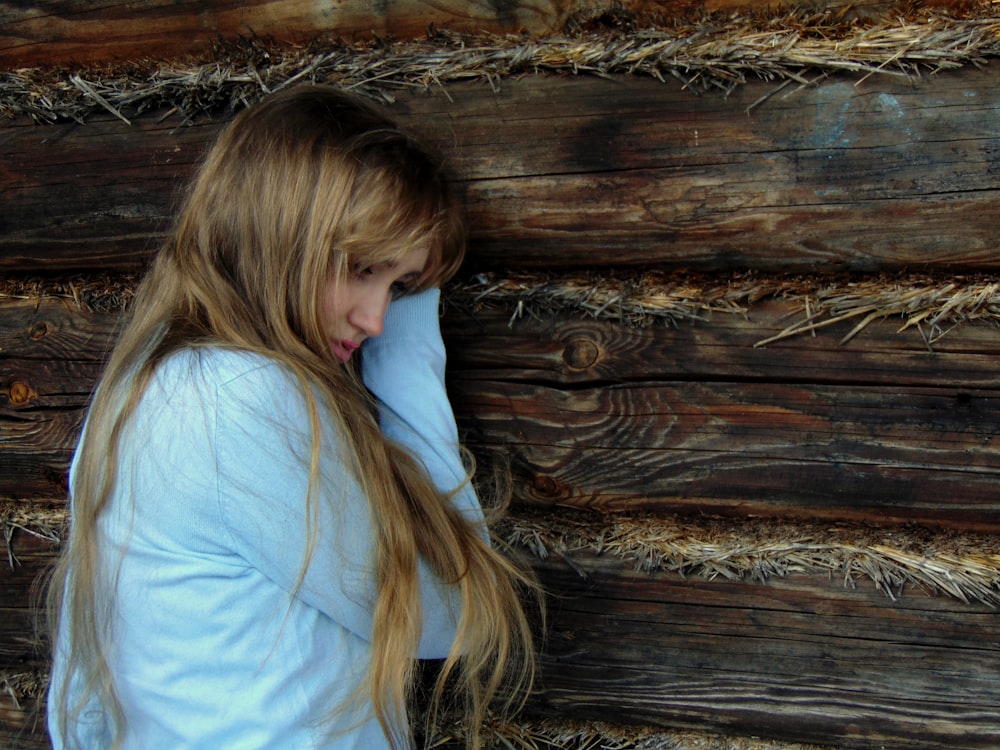 woman leaning on black wooden wall