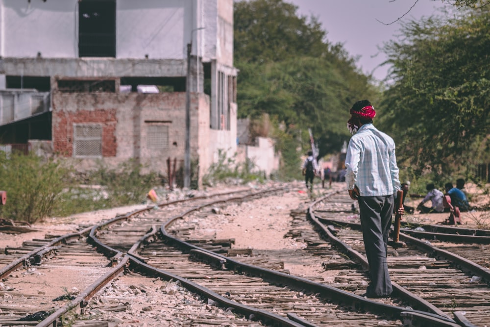 man standing on train rails