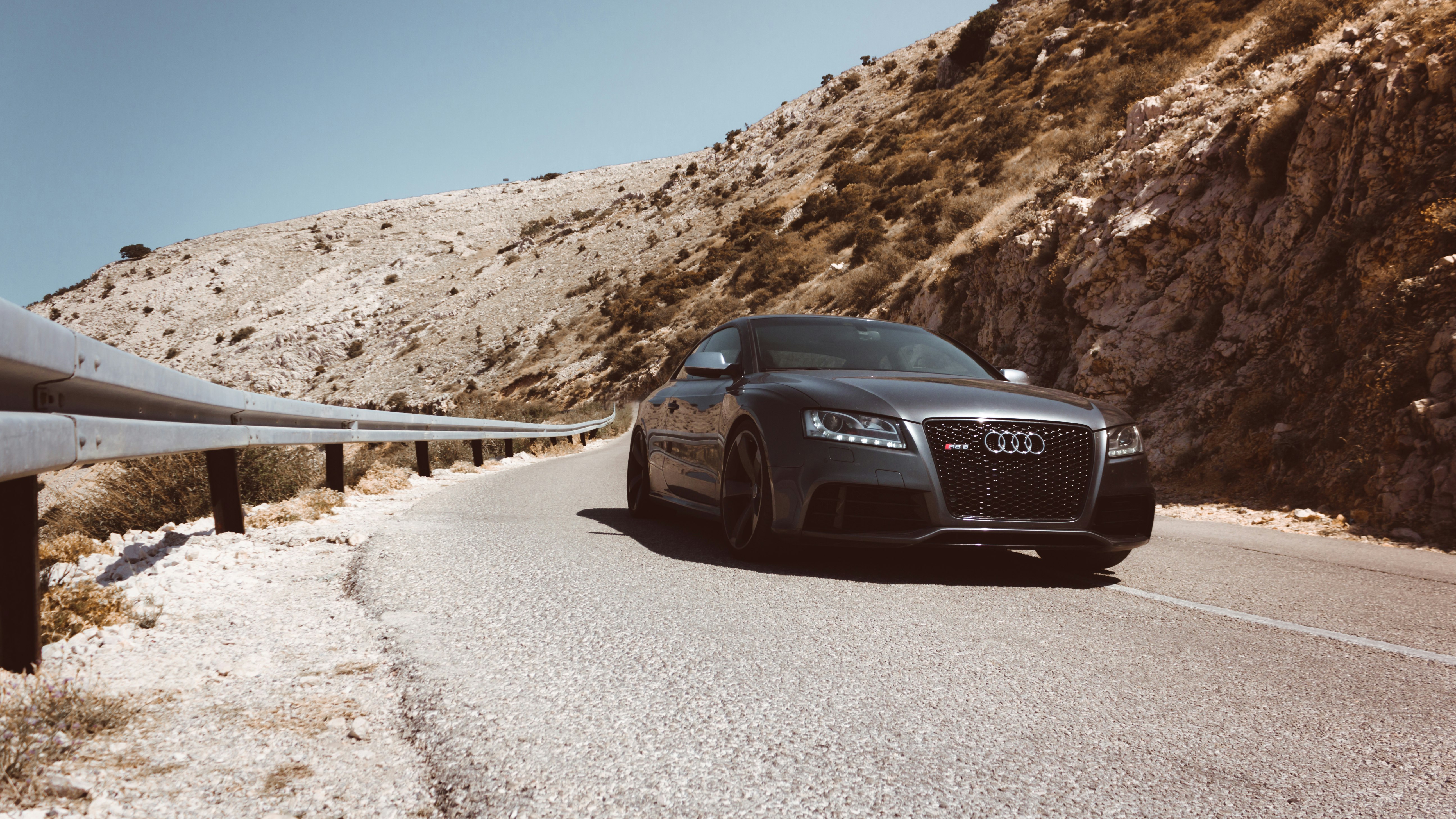 black Audi car passes on asphalt road