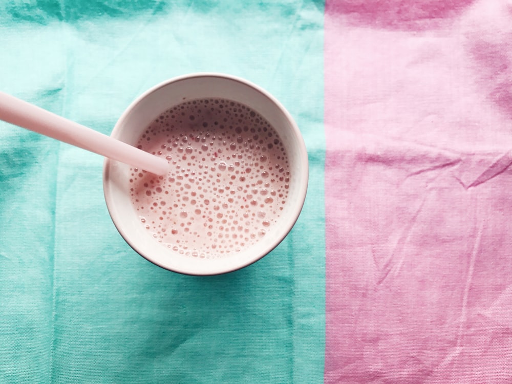 a cup of milk with a straw in it