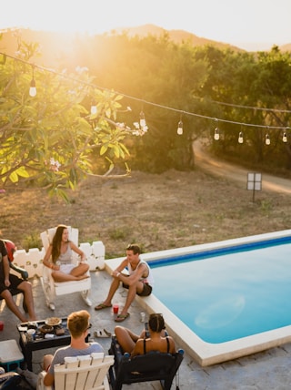 people sitting on chairs near pool