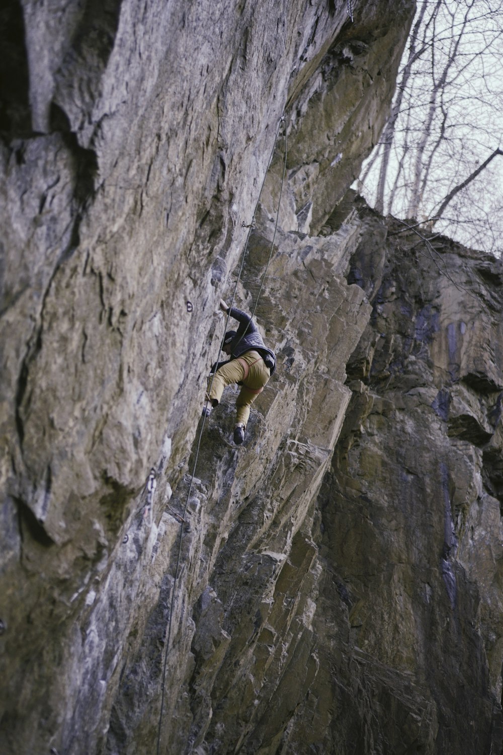 Un homme grimpant sur le flanc d’une montagne