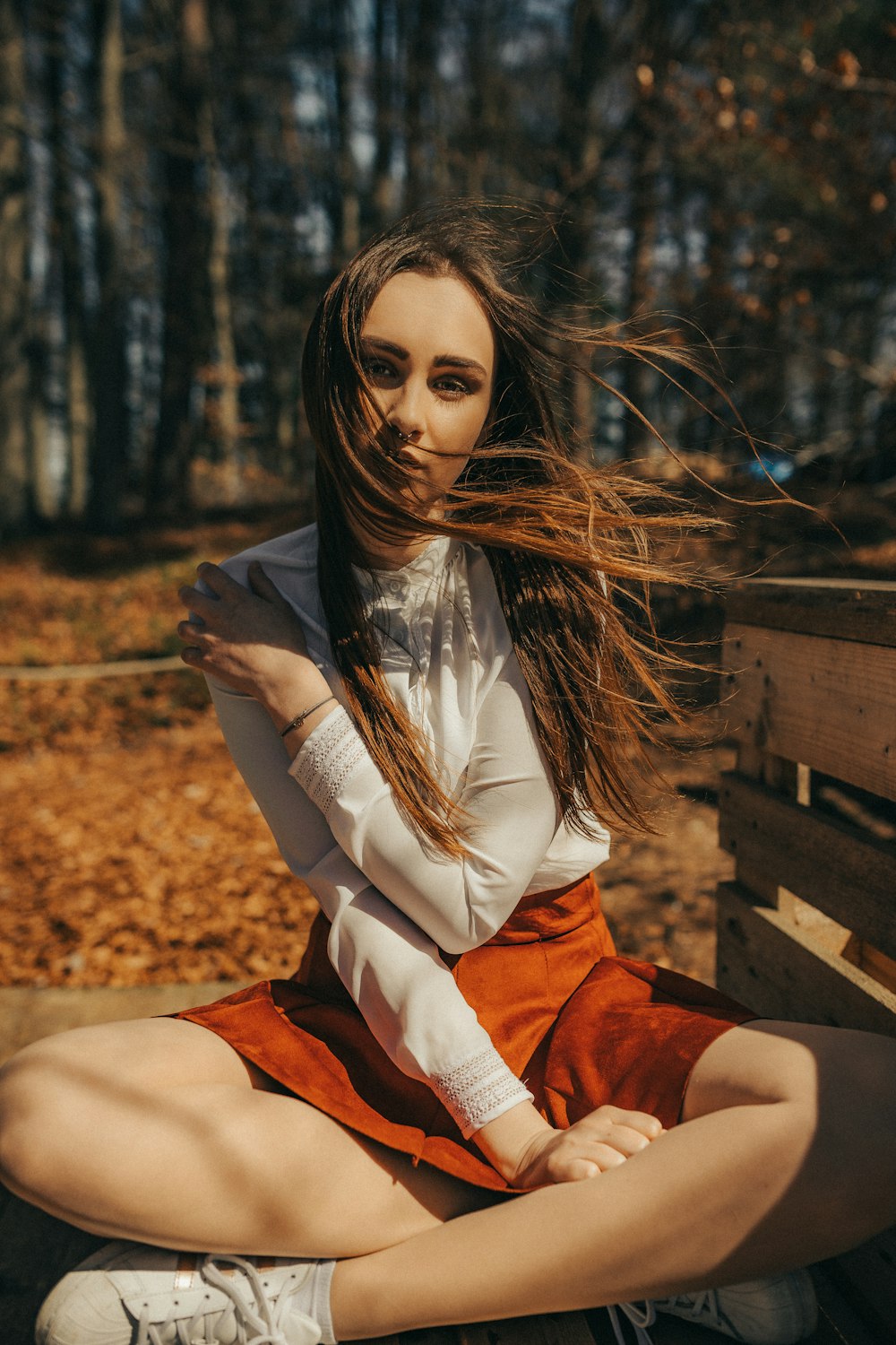 women's sitting near gray wooden crate outdoors