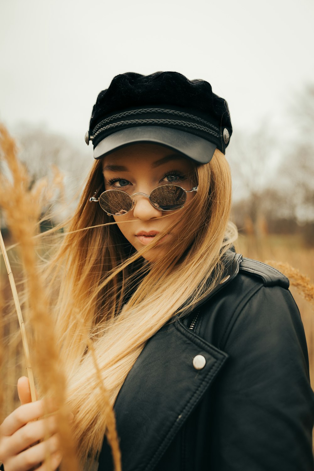 Frau mit Sonnenbrille und Stock in der Hand