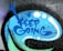The image depicts a graffiti-style artwork on a textured surface. The words 'KEEP GOING' are spray-painted in blue within a speech bubble-like shape. Surrounding the text are abstract blue and white dots and lines, which add to the dynamic and encouraging visual appeal.