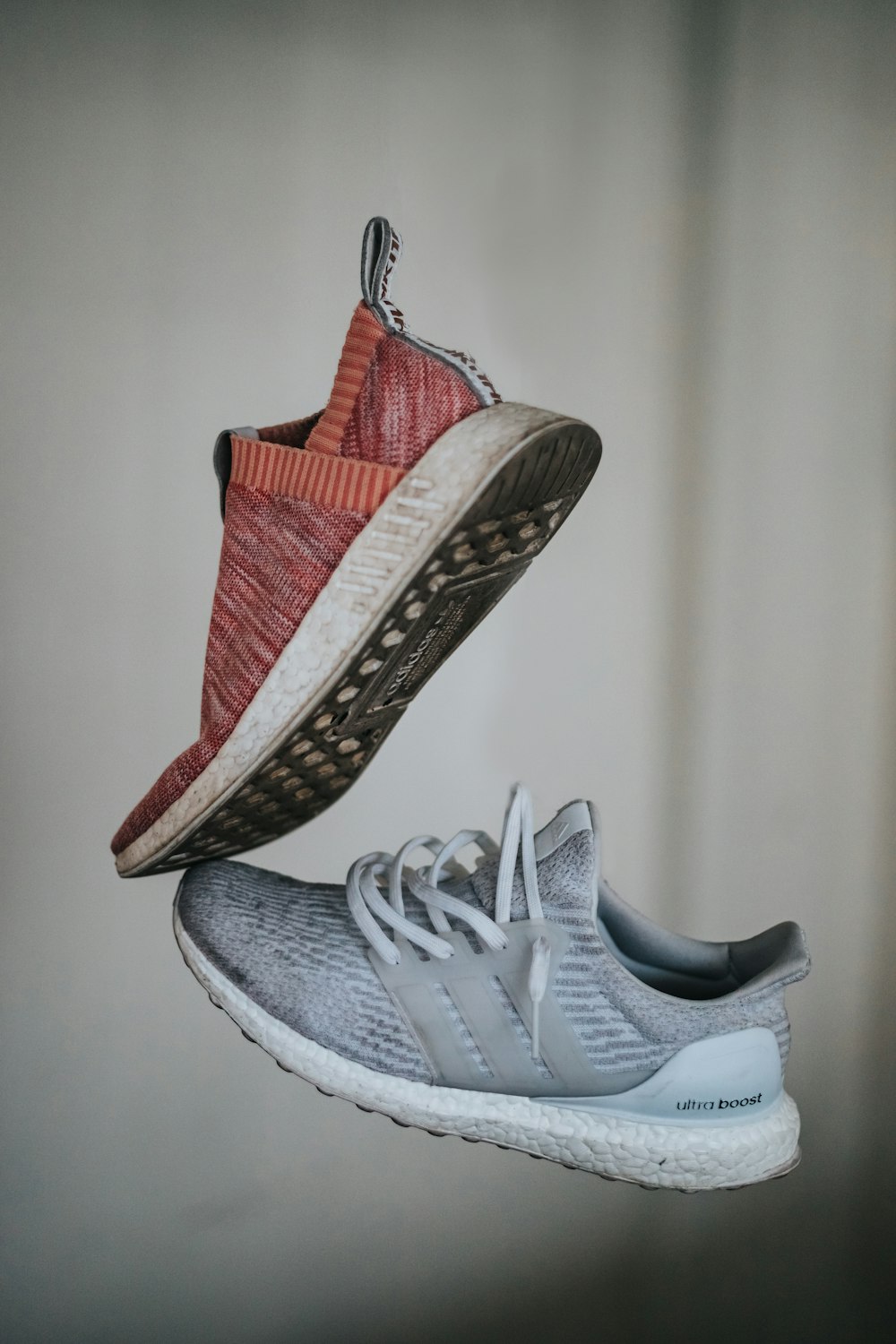 two unpaired brown and gray adidas running sneakers
