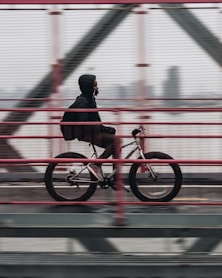 man riding bicycle on bridge