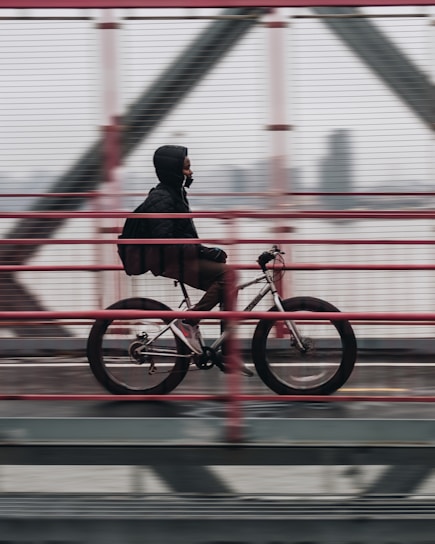 man riding bicycle on bridge