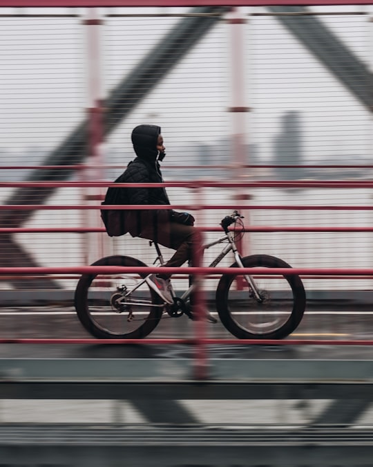 man riding bicycle on bridge in Williamsburg Bridge United States