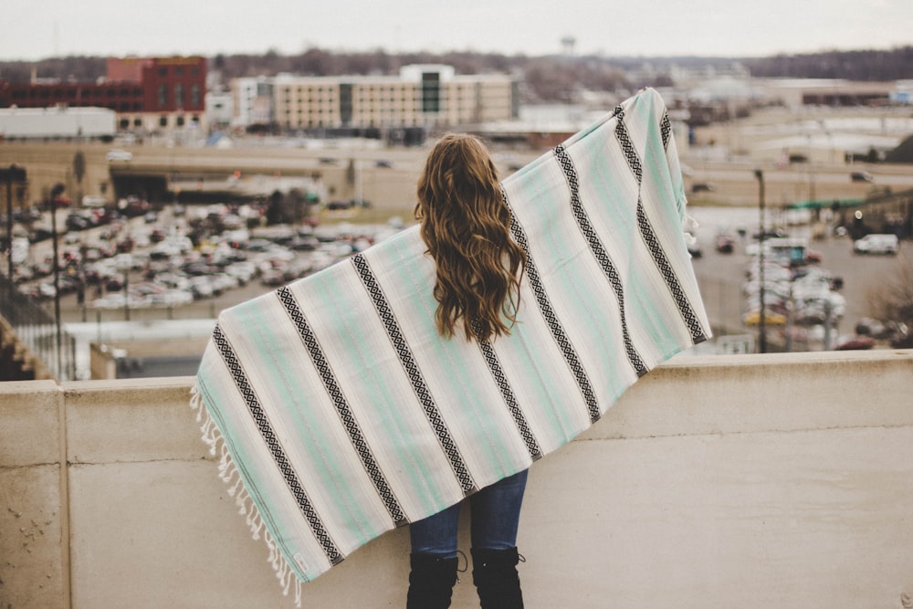 woman covered with teal, white, and black shawl