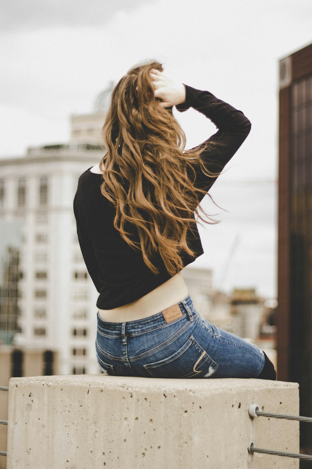 woman sitting while holding her hair