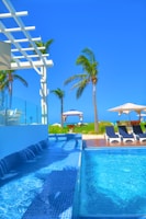 Modern blue-themed swimming pool in a luxurious home backyard.