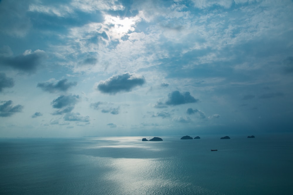 rocks on body of water under clouds