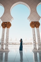 woman standing on white tiled floor in the middle of concrete pillars