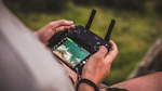 Technician controlling a drone from the ground with a scenic view of the PACA region.