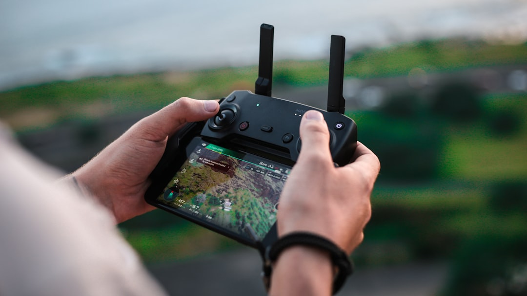 person holding smartphone with Bluetooth controller