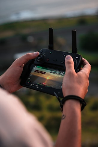 person holding drone controller with monitor at daytime