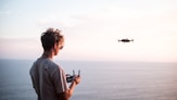 man using quadcopter drone near sea during daytime