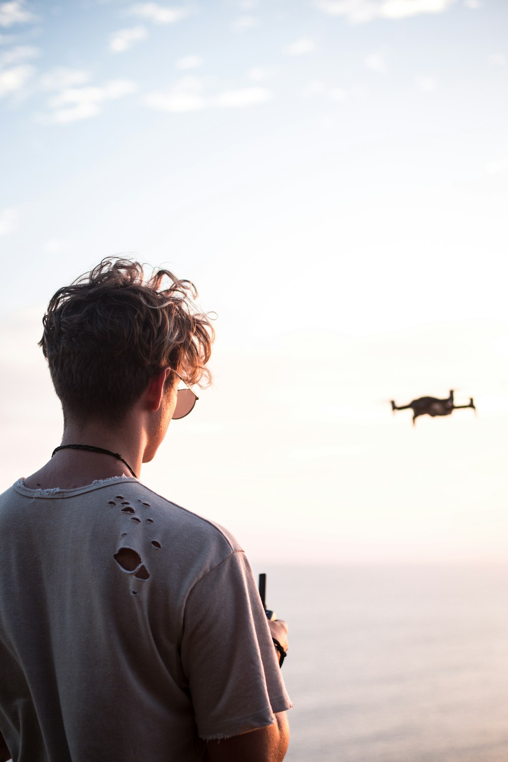 man controlling drone at daytime