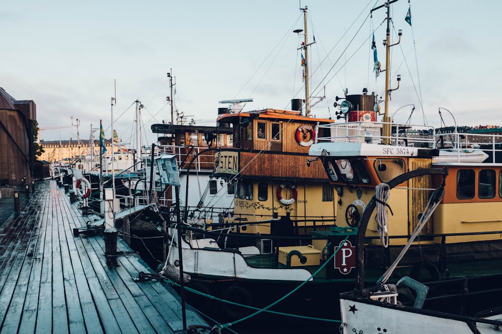 white and brown ships near black dock at daytime