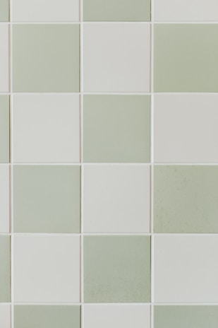 Modern rounded tile samples in various shades of green arranged neatly