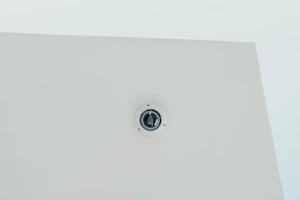 Minimalist dome camera installed on a white ceiling with soft natural light
