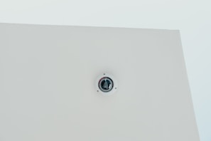 A sleek smoke detector alarm mounted on a ceiling.