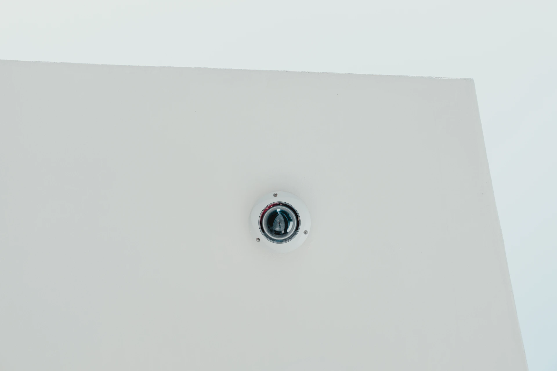 A close-up of a fire alarm system mounted on a ceiling, highlighting the clean installation in a commercial space.
