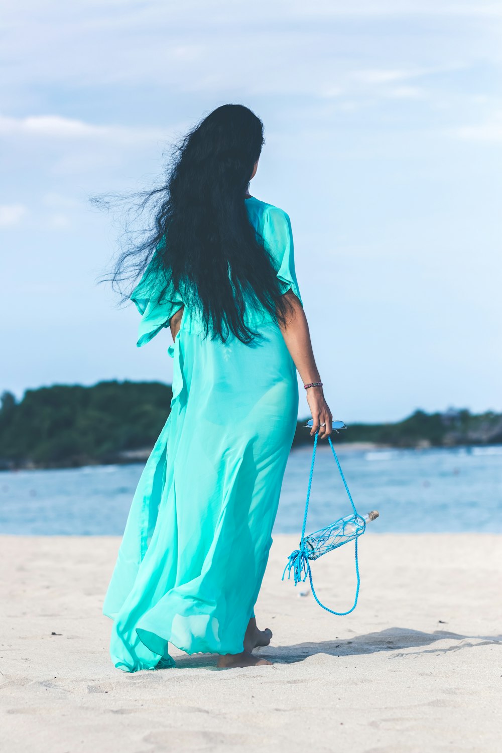 woman holding bottle near the seashore