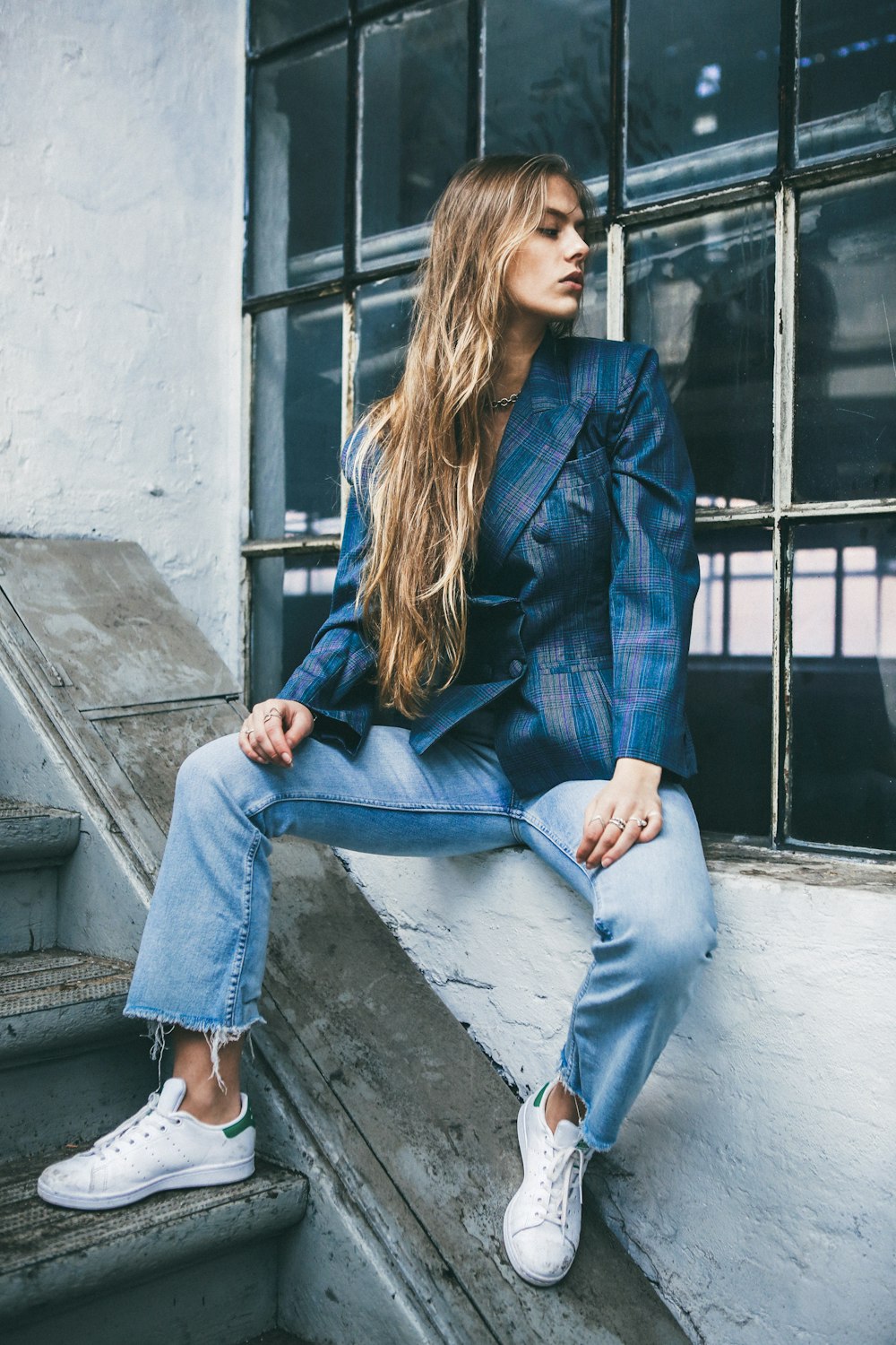 woman sitting on window near staircase