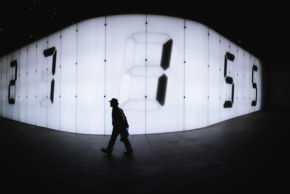 LED 간판 근처를 걷는 남자의 사진