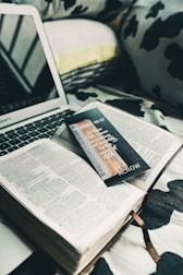 A cozy room setup showing a laptop and guidebook open to tips on finding accommodation.
