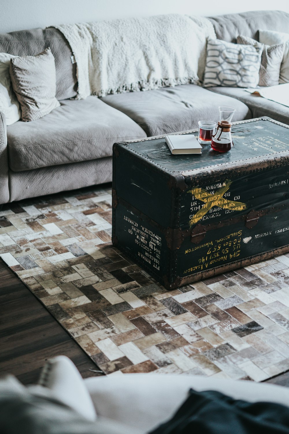 black ammo box coffee table between sofas