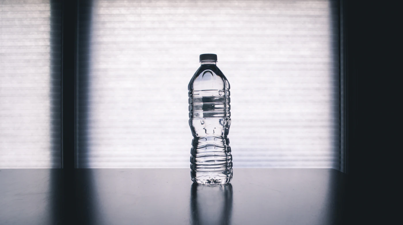 Sunlight streaming through a window onto a glass of water on a wooden table