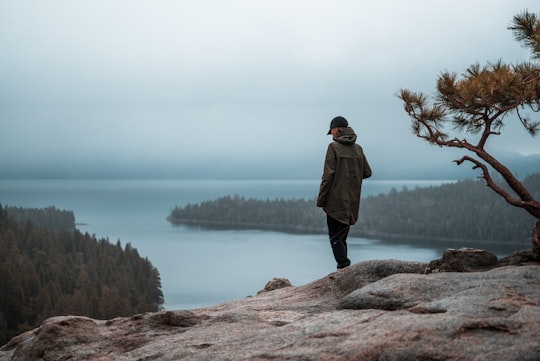 woman standing on cliff in Emerald Bay State Park United States