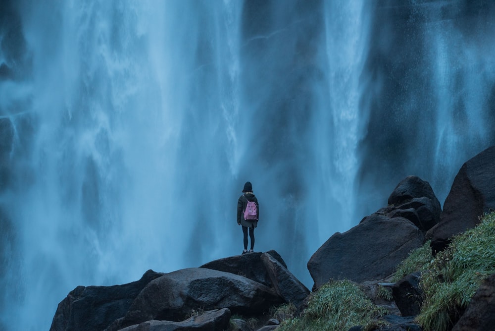 woman standing on edge waterfalls