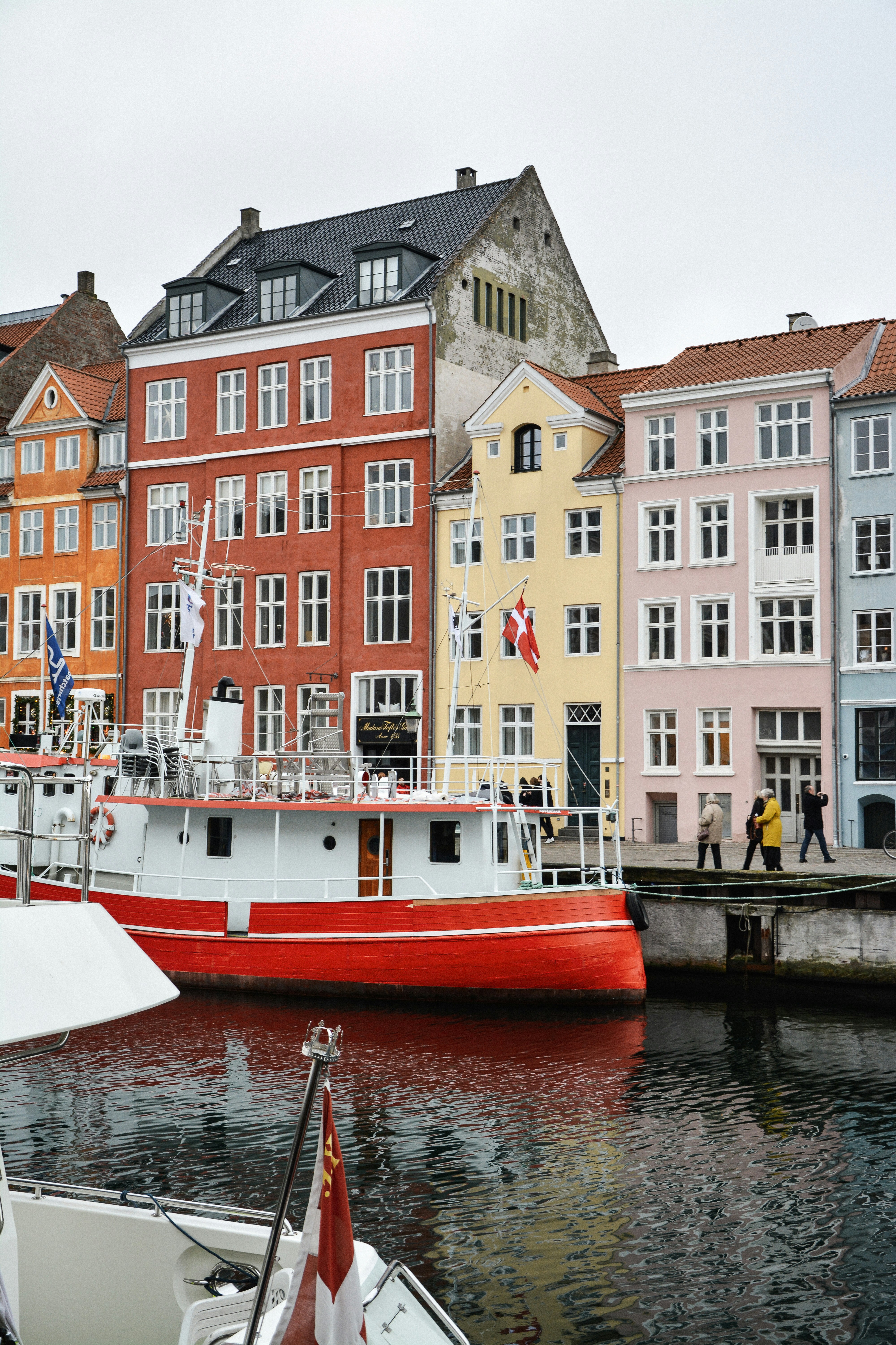 red boat on side of road near buildings